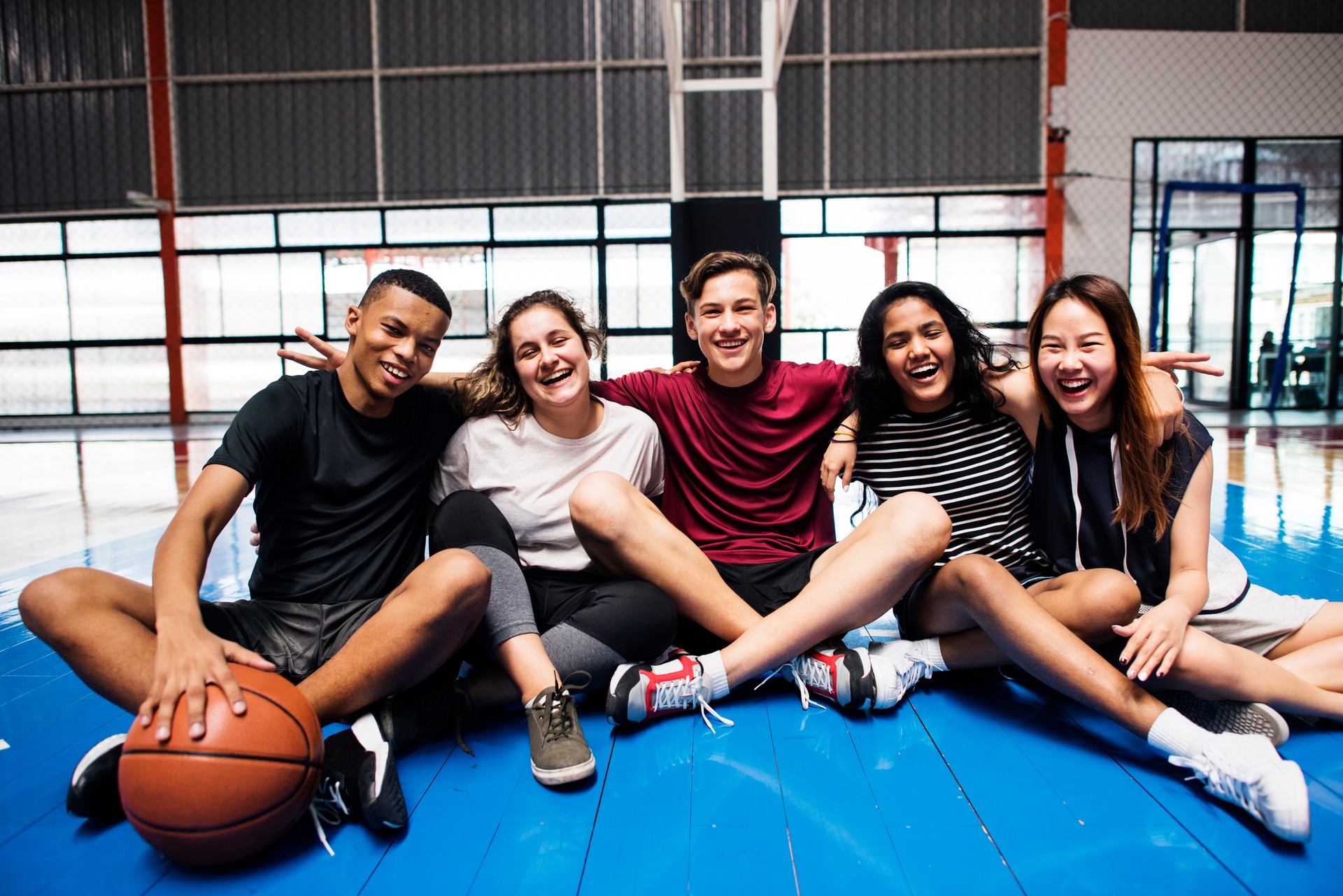 Group of young teenager friends on a basketball court relaxing portrait Group of young teenager friends on a basketball court relaxing portrait
